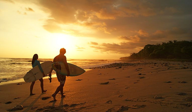 Surfers walking on a beach in Costa Rica